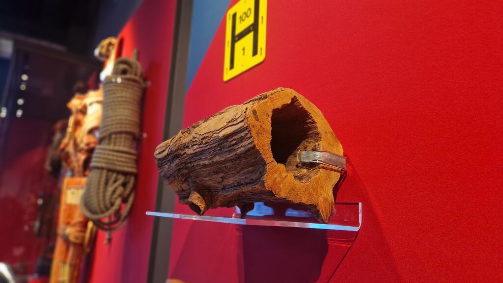This image shows a preserved wooden water pipe, dating to around 1700, on display at the Museum of Scottish Fire Heritage. Made by boring through a solid length of tree trunk, this particular section was unearthed in Hawick by firefighters.